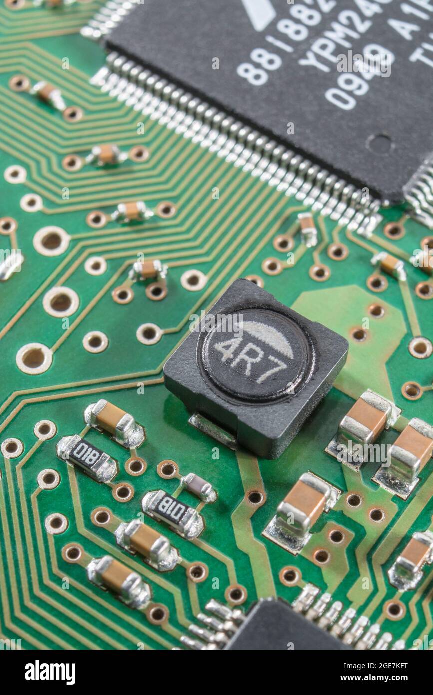 Close-up of a shielded power inductor on a surface mount / SM pcb (shielding cuts magnetic interference) + other SM components. Brands not known. Stock Photo