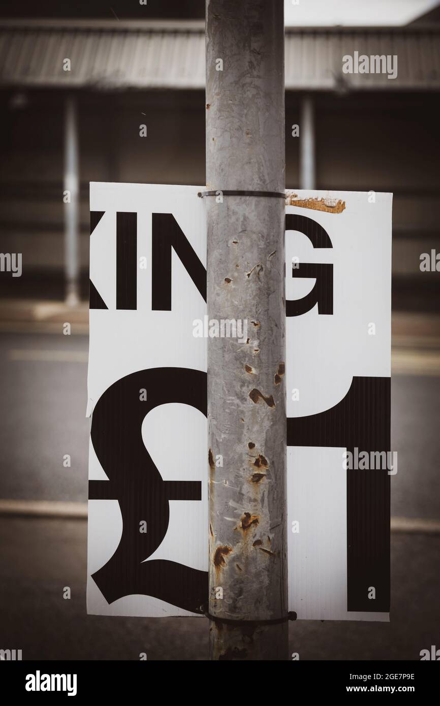 Incomplete parking sign partly obscured by a pole. Stock Photo