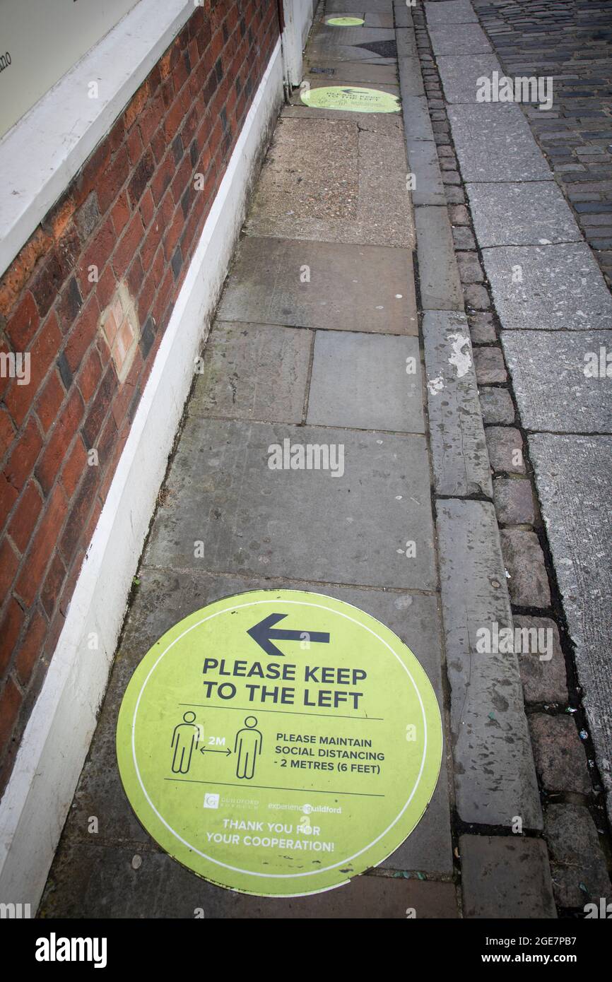 Sign on the pavement advising pedestrians to 'keep left' and maintain 'social distancing' during the Covid -19 pandemic. Stock Photo