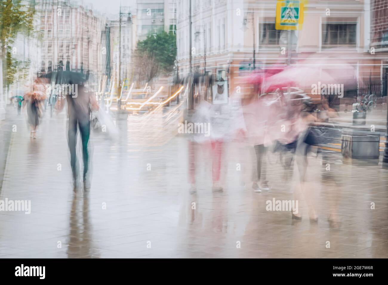 Abstract people under umbrellas in city, rainy weather, blurred motion ...