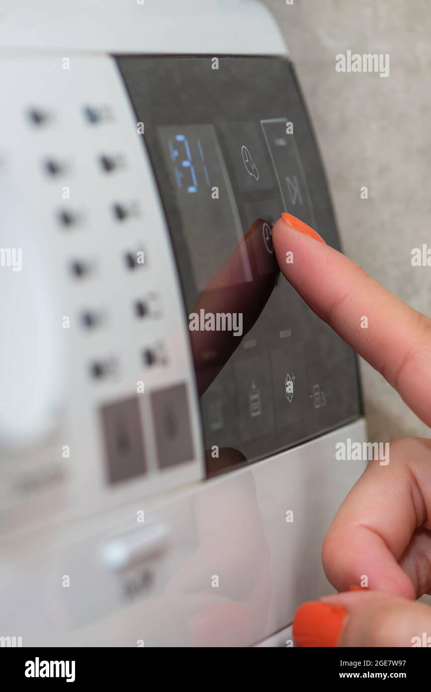 Washing machine. The hand turns on the washing machine or the choice of