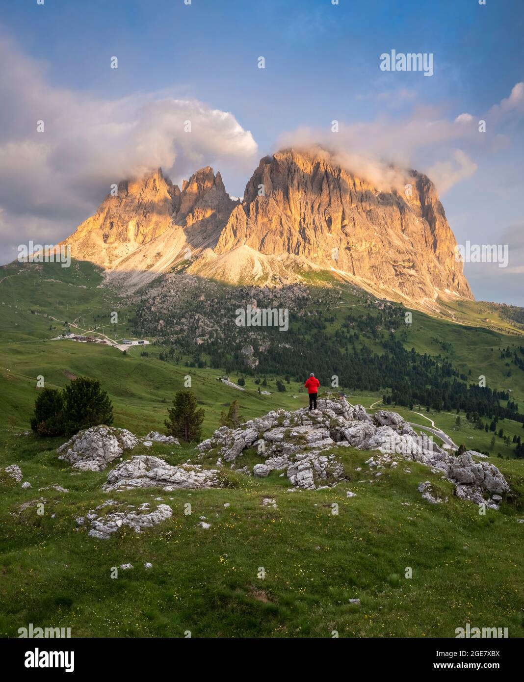 Aerial view of a person admiring Sassolungo group during a summer sunrise. Sella Pass, Dolomiti, Bolzano district, Trentino Alto Adige, Italy, Europe. Stock Photo