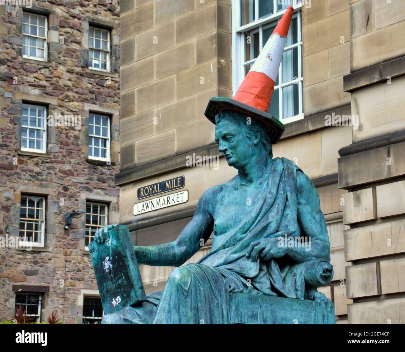 Edinburgh, Scotland, 17th  August, 2021. UK  Weather: SThe john hume statue gers the cone headed man treatment. unny day saw Festival Fringe street return as   happy locals and tourists enjoy sitting in the sun and a little humour and fun  in the city . Credit Gerard Ferry/Alamy Live News Stock Photo