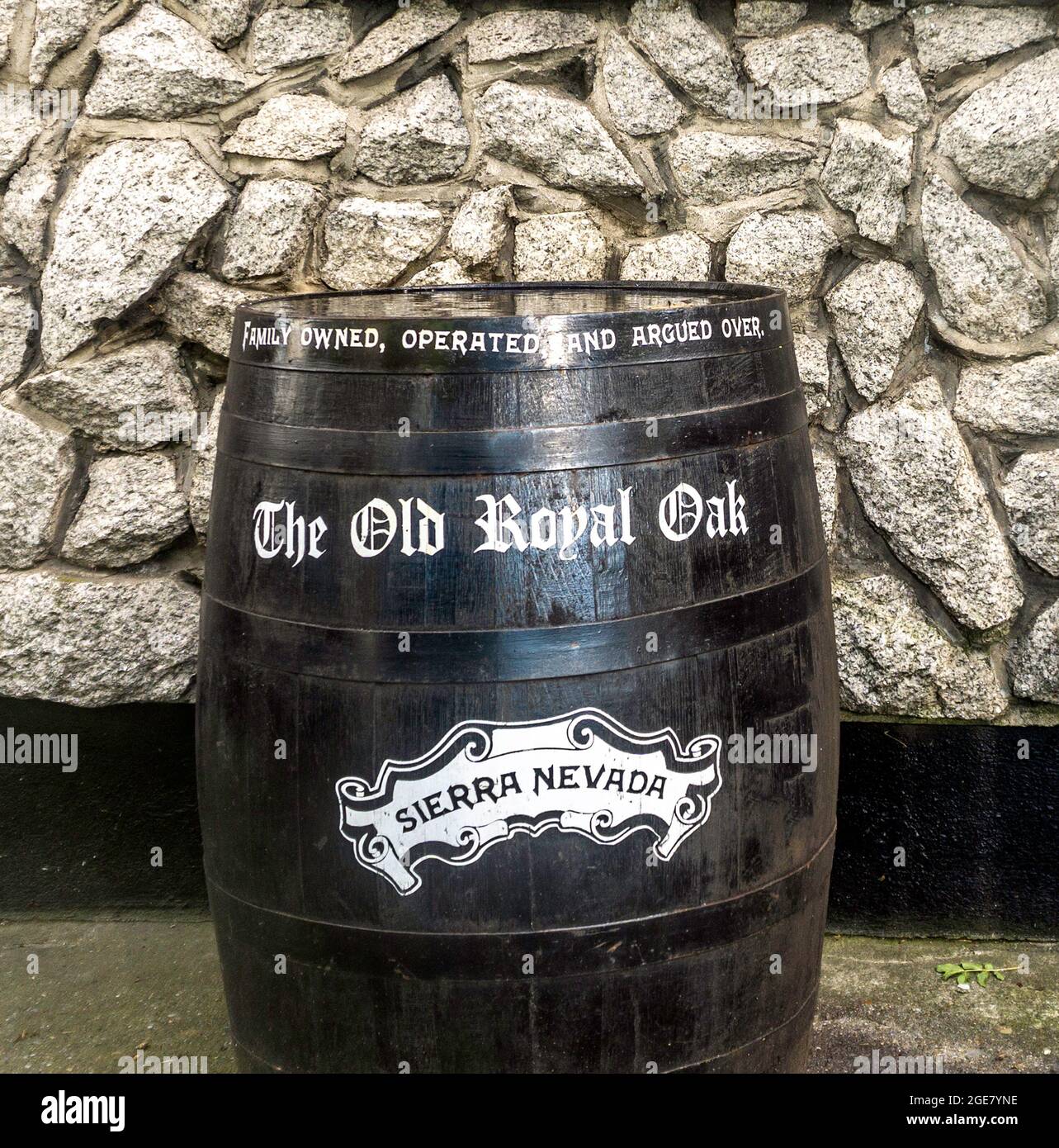 An old whiskey barrel outside the Old Royal Oak pub in Kilmainham, Dublin, Ireland, bearing the legend, ‘family owned, operated and argued over’. Stock Photo