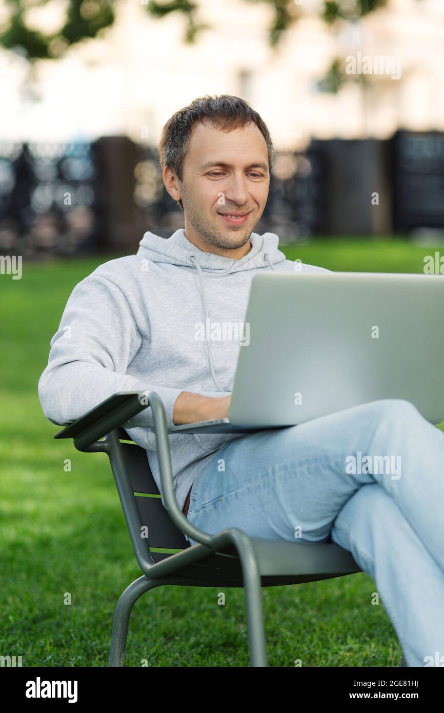 Blogger Man Work On Laptop In Public Park Processes Video For Social Media Content Sit In