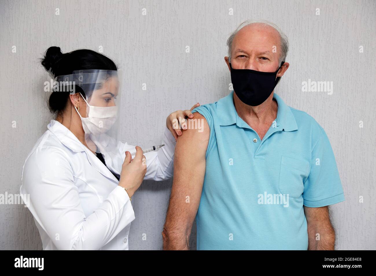 adult white male receives vaccine or medication through intravenous injection in the arm Stock Photo