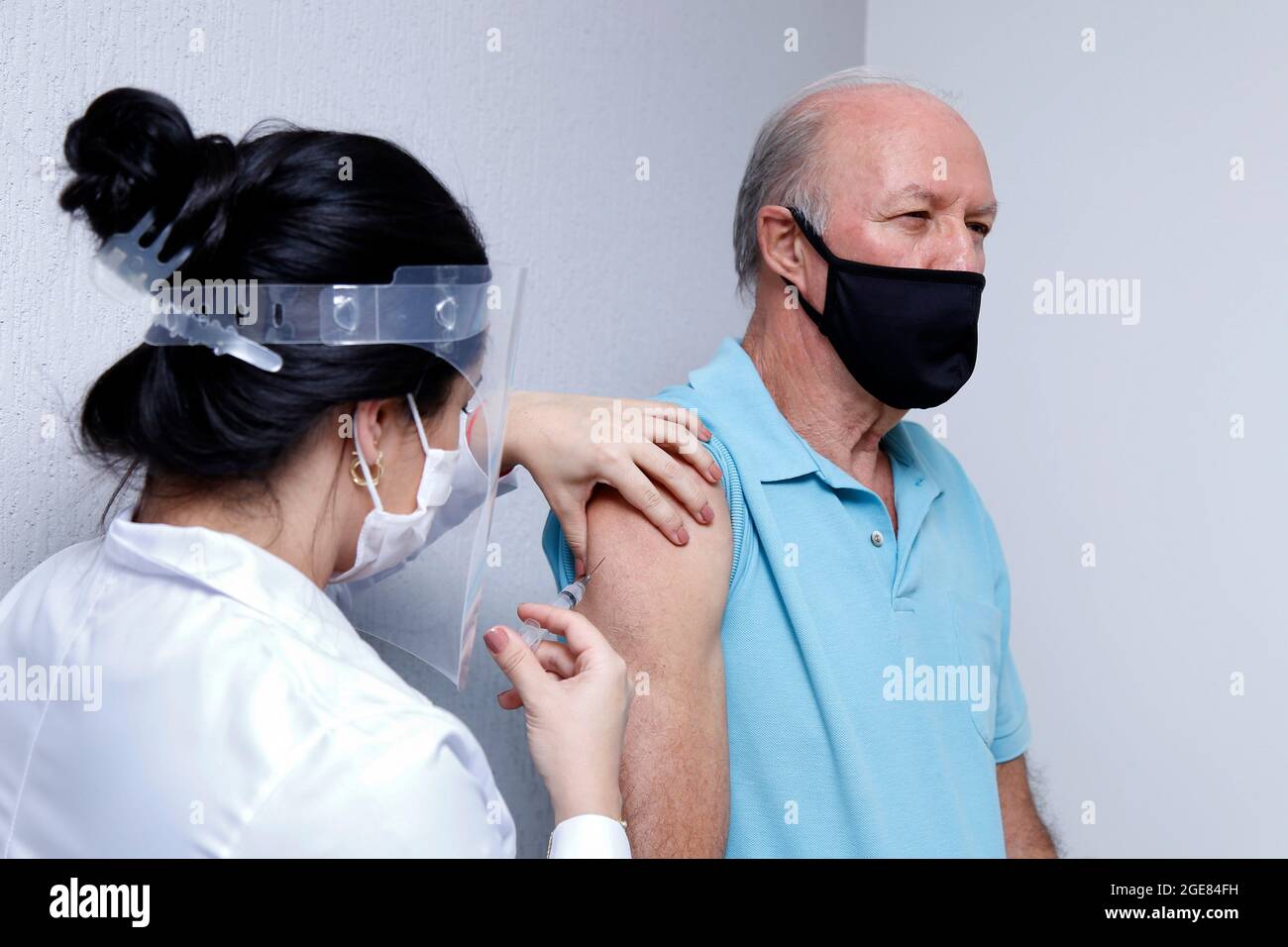 adult white male receives vaccine or medication through intravenous injection in the arm Stock Photo