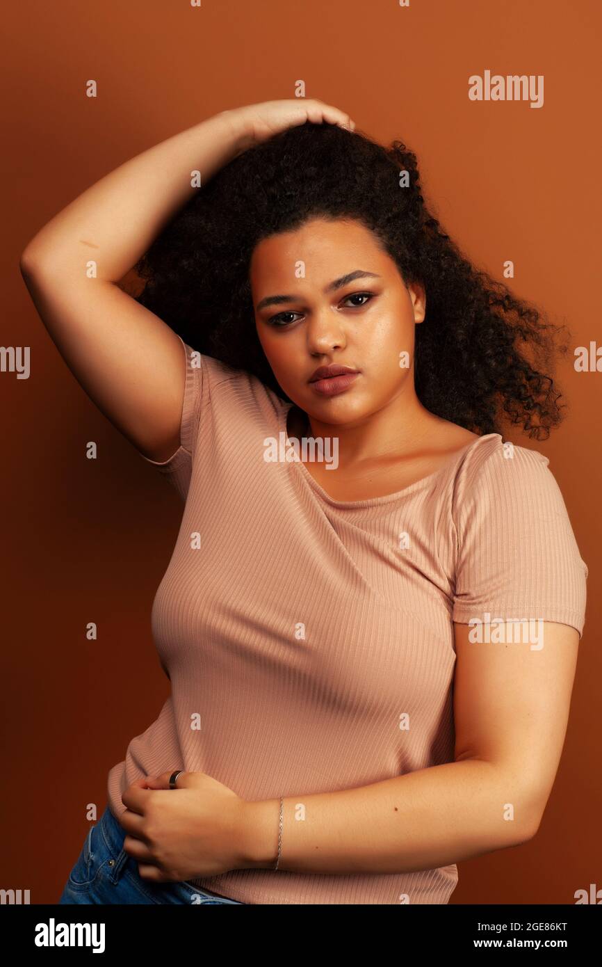 pretty young african american woman with curly hair posing cheerful ...