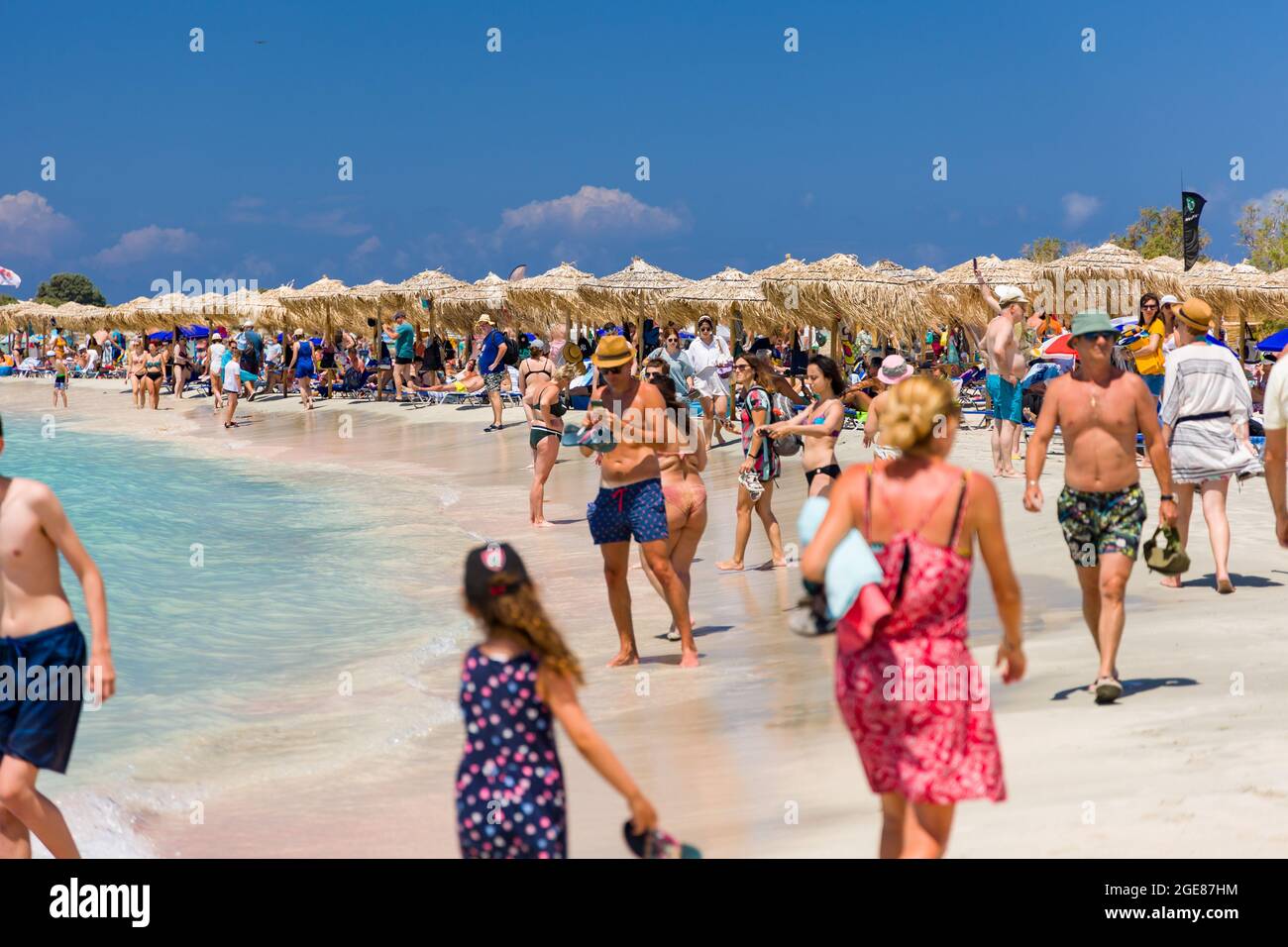 ELAFONISI, CRETE - JULY 19 2021: Crowds of tourists on the picturesque beach and shallow lagoons at Elafonissi on the Greek island of Crete. Stock Photo