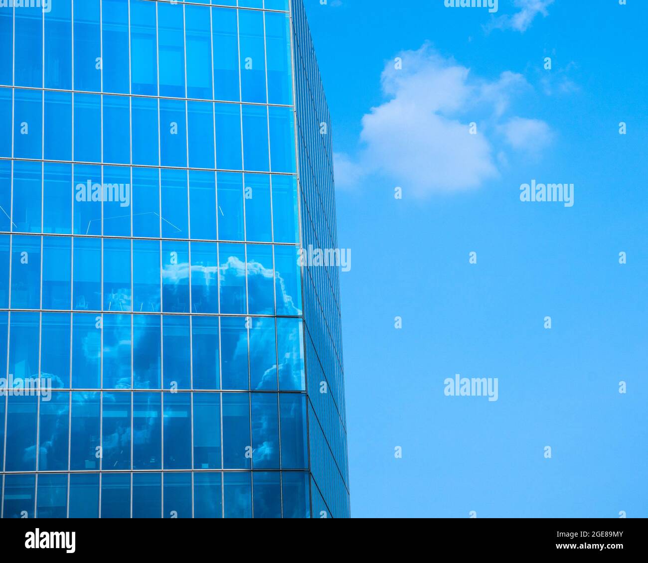 Modern glass business office building with blue sky and clouds in ...