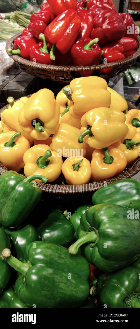Three variants of the bell pepper on display in a market Stock Photo