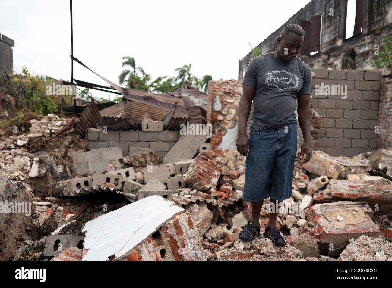 Les Cayes, Haiti. 17th Aug, 2021. A man stands on the debris of a