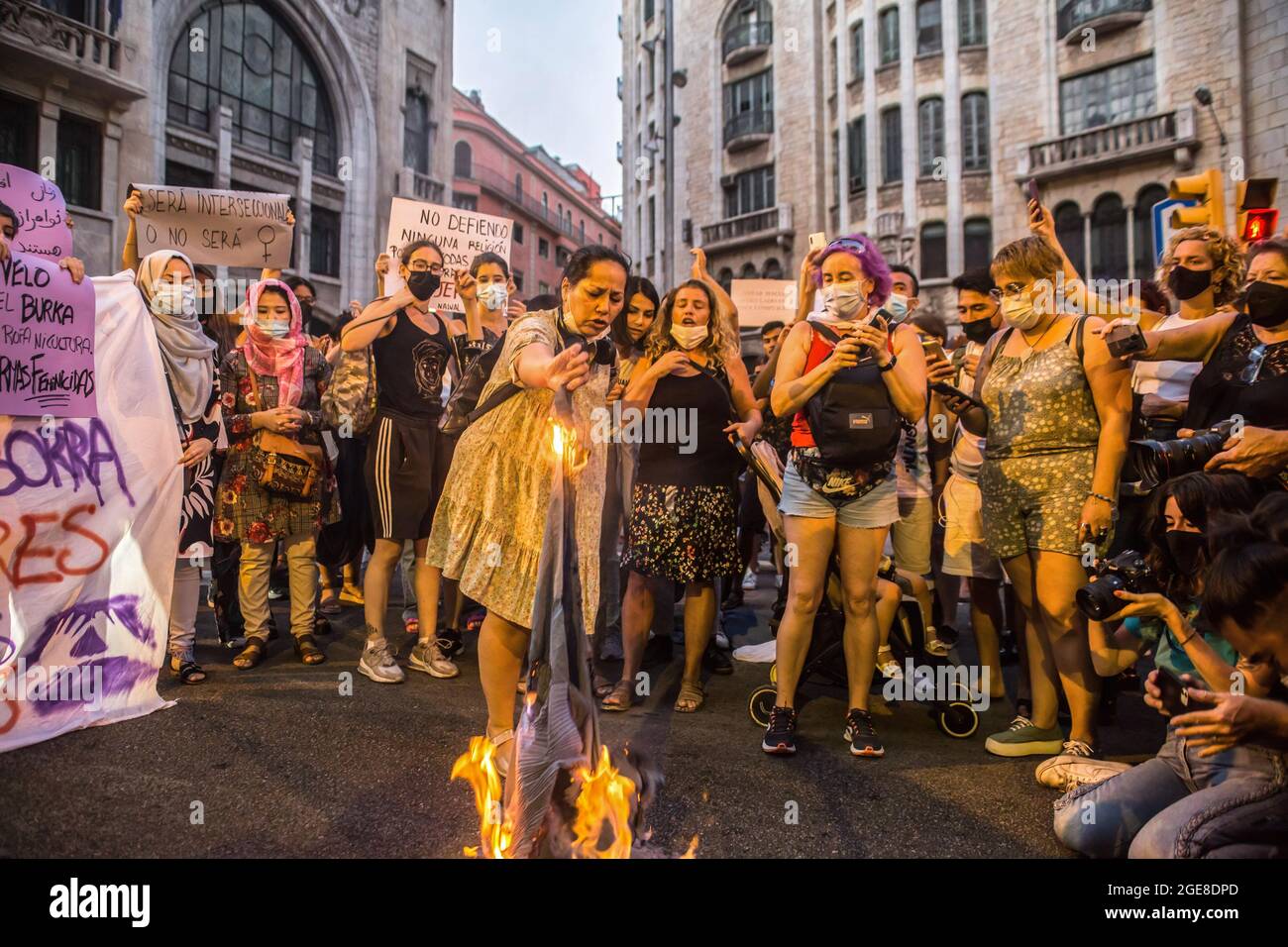 Barcelona, Spain. 17th Aug, 2021. Demonstrators are seen burning a burqa during the demonstration. Around a hundred women have participated in a feminist demonstration in front of the United Nations headquarters in Barcelona to demand an urgent international response to protect Afghan women and girls. Credit: SOPA Images Limited/Alamy Live News Stock Photo