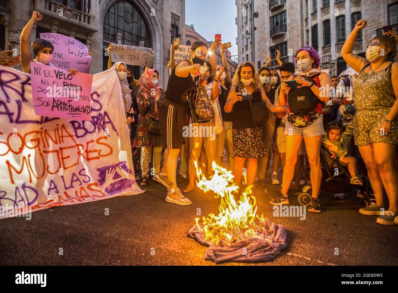 Barcelona, Spain. 17th Aug, 2021. Demonstrators are seen burning a burqa during the demonstration. Around a hundred women have participated in a feminist demonstration in front of the United Nations headquarters in Barcelona to demand an urgent international response to protect Afghan women and girls. (Photo by Thiago Prudencio/SOPA Images/Sipa USA) Credit: Sipa USA/Alamy Live News Stock Photo