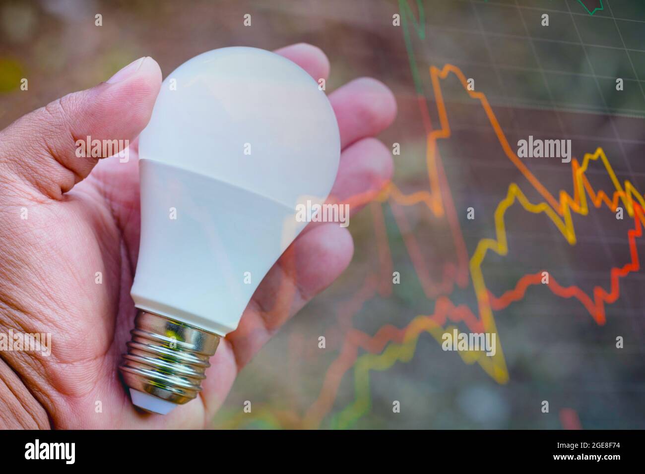 In this photo illustration a hand holding a LED light bulb (light