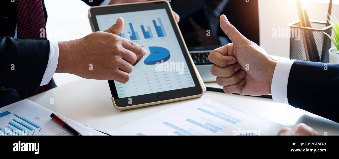 Cropped shot of a group of businesspeople looking at graphs on digital tablets, Analyzing electronic document, Discussing plan and idea to improvement Stock Photo