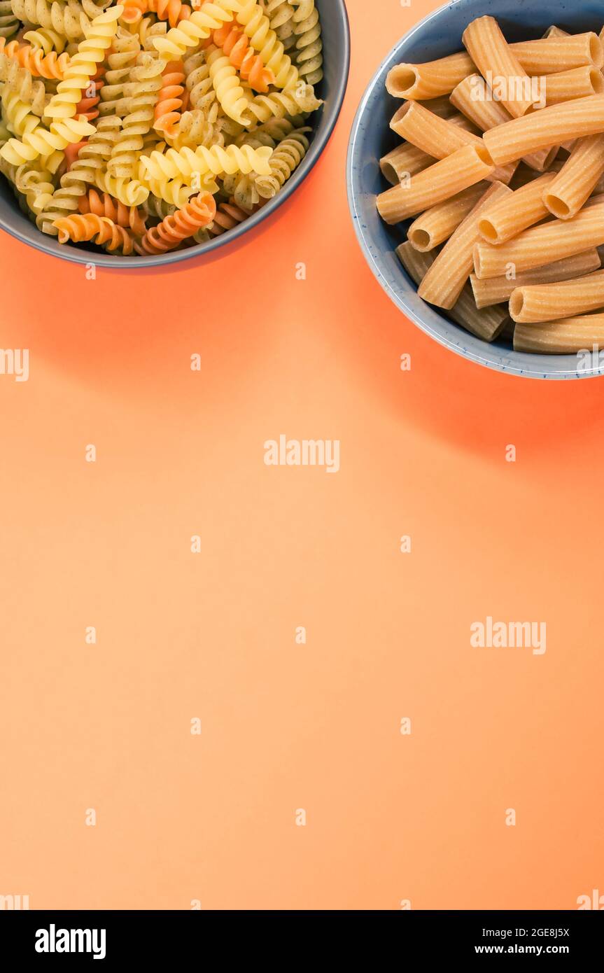 Vertical shot of tricolor rotini and rigatoni pasta on a bowl isolated