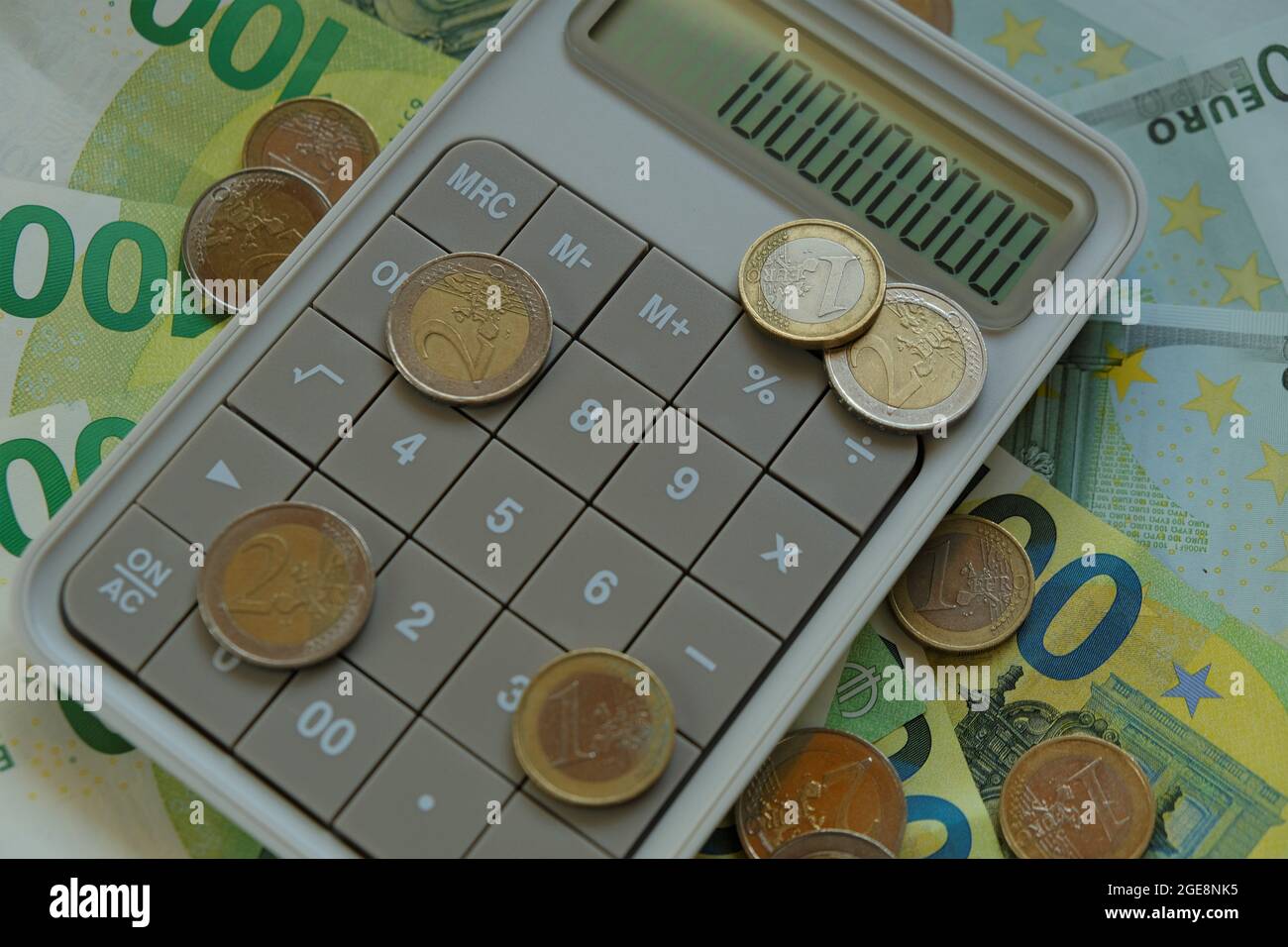 Counting money.Euro bills and coins.Finance and savings. one hundred euro banknotes, euro coins gray calculator. Expenses and income. Stock Photo