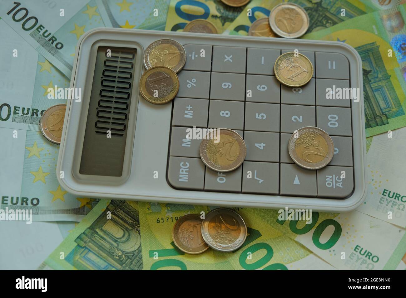 Counting money.Euro bills and coins.Finance and savings. one hundred euro banknotes, euro coins gray calculator. Stock Photo