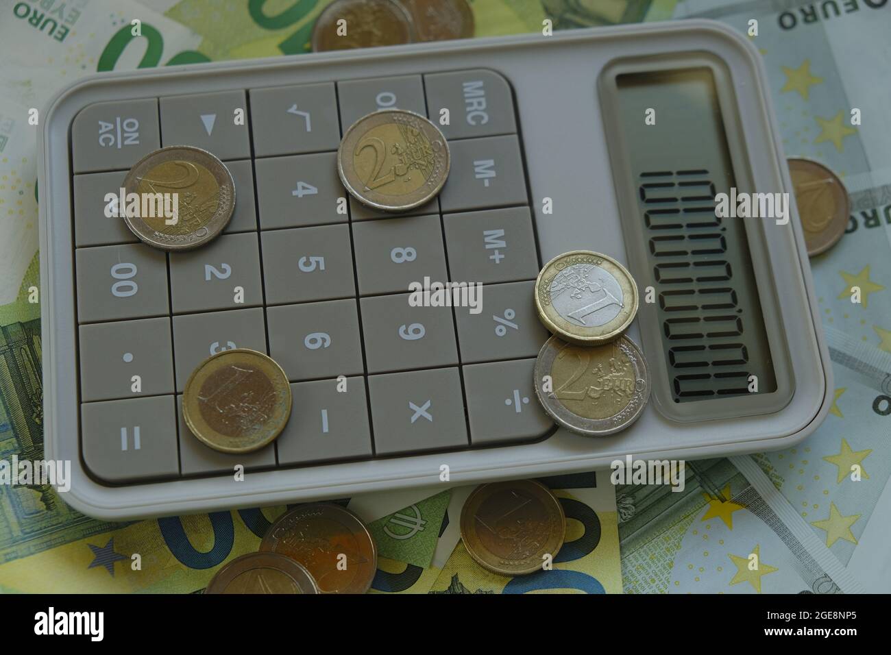 Finance and savings. Counting money.Euro bills and coins.one hundred euro banknotes, euro coins gray calculator. Expenses and income. Stock Photo