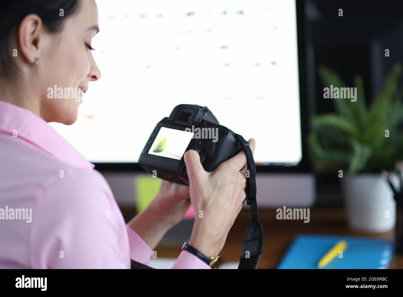 Woman holds camera and presses buttons at workplace closeup Stock Photo