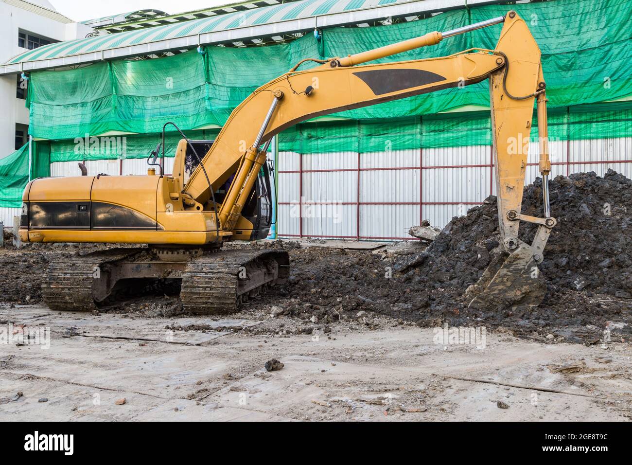 Yellow excavator on a construction site background Stock Photo - Alamy