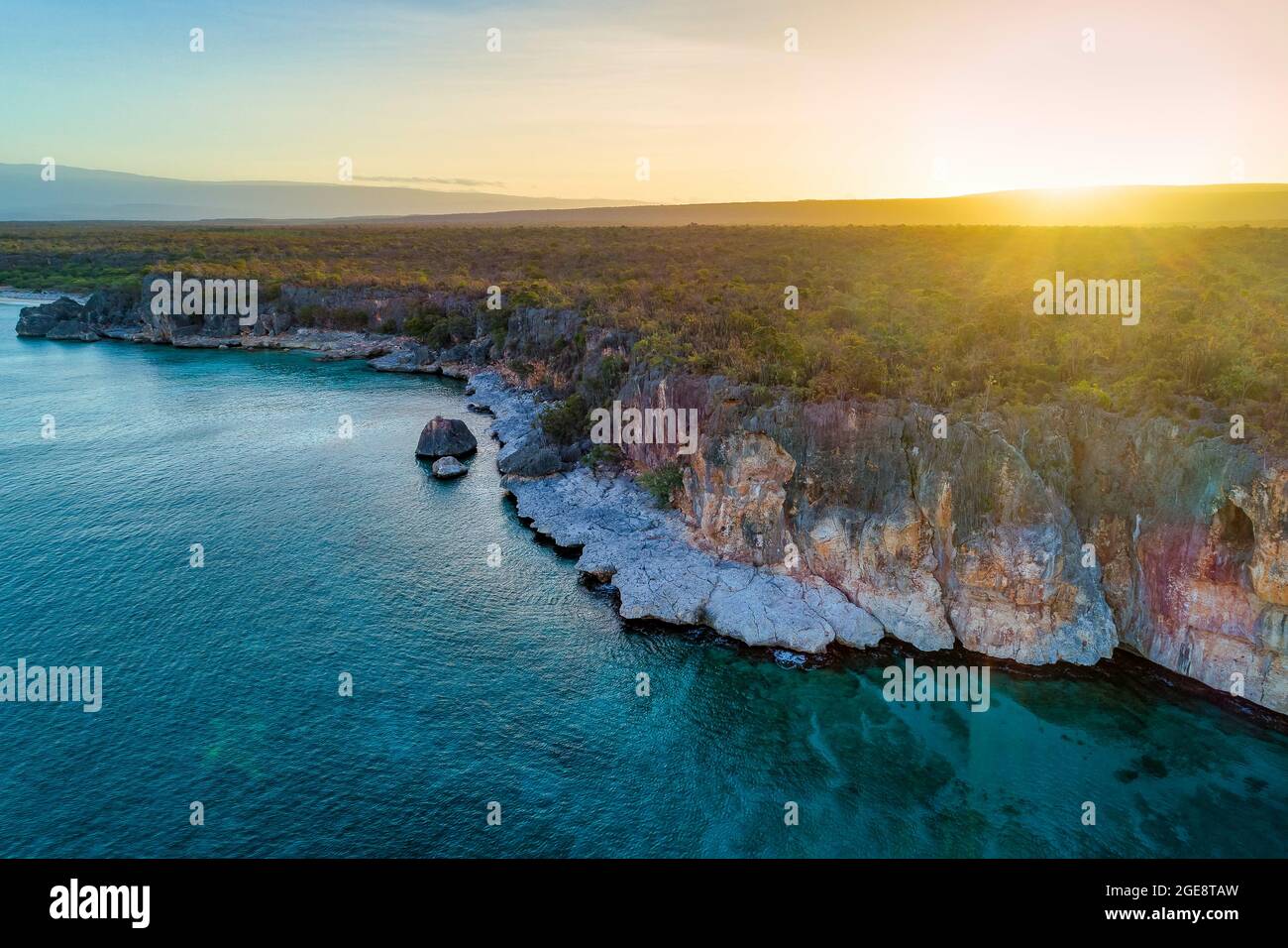 Landscape of rocky cliffs covered in greenery surrounded by the sea ...