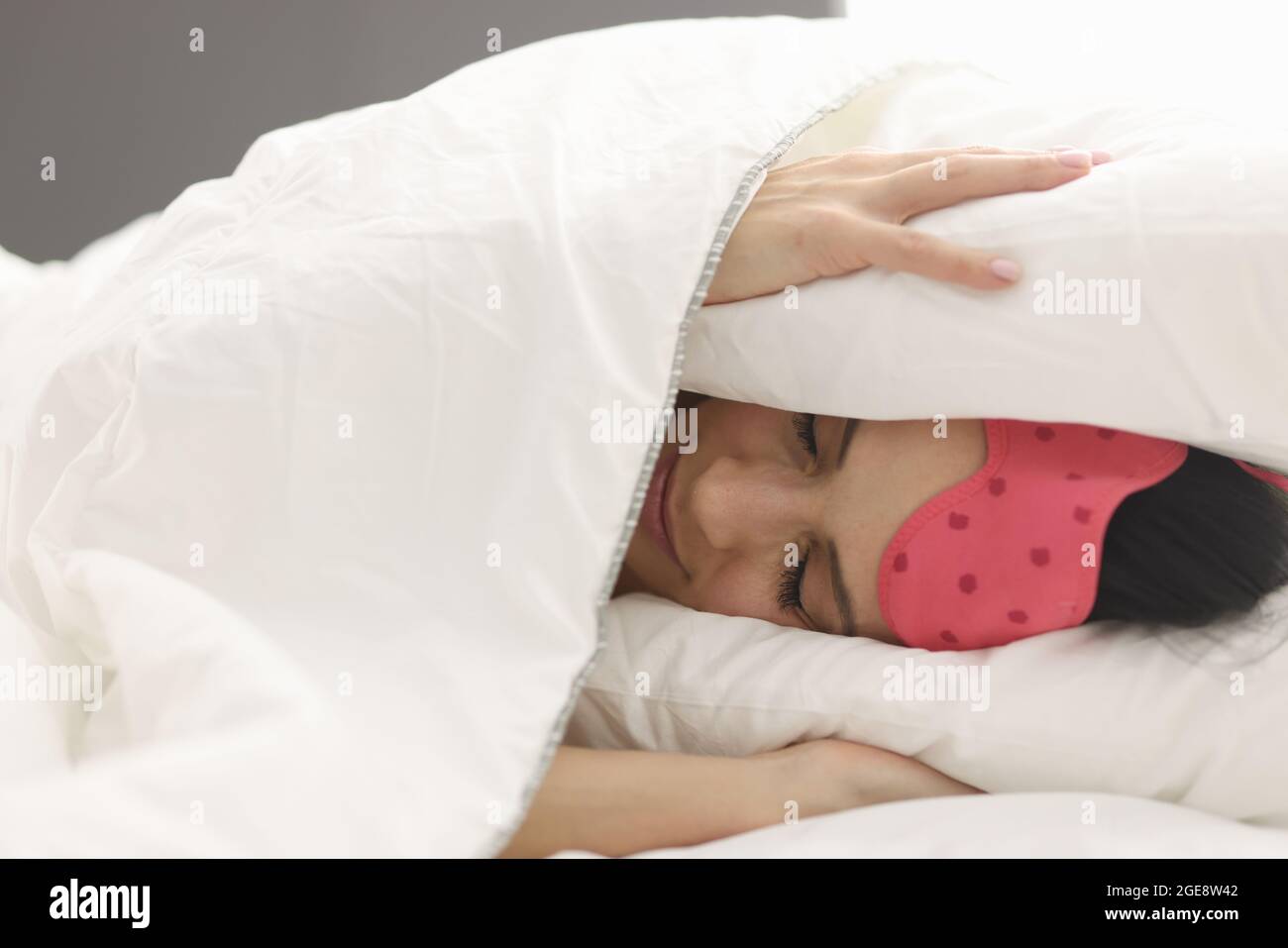 Woman lies in bed covering head with blanket closeup Stock Photo Alamy