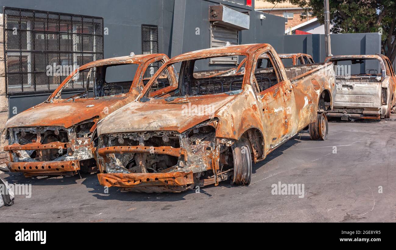 Four fire destroyed burnt car vehicles roadside from riots and arson Stock Photo