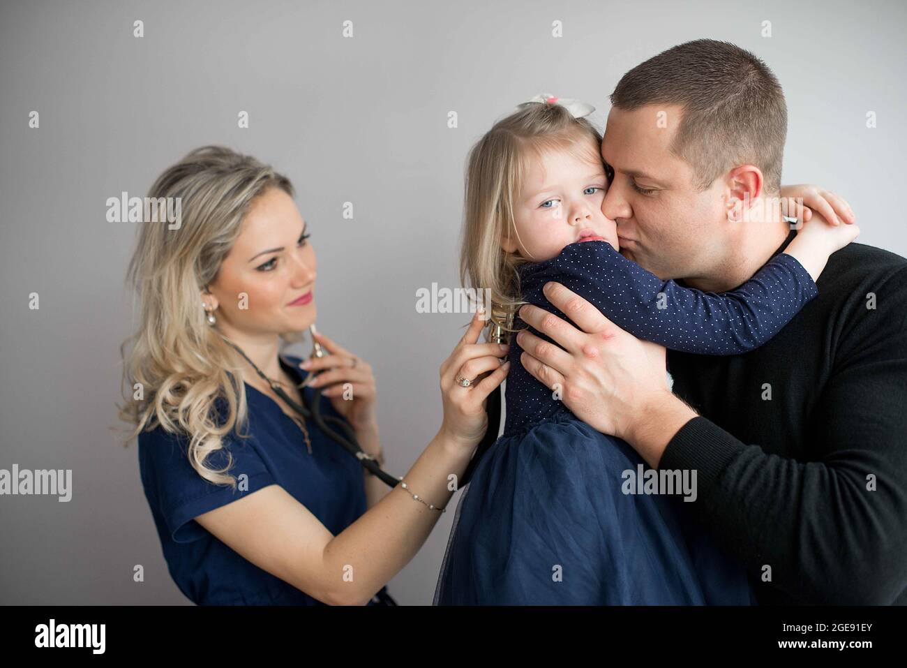 Father with girl being examined by friendly female pediatrician in clinic Stock Photo