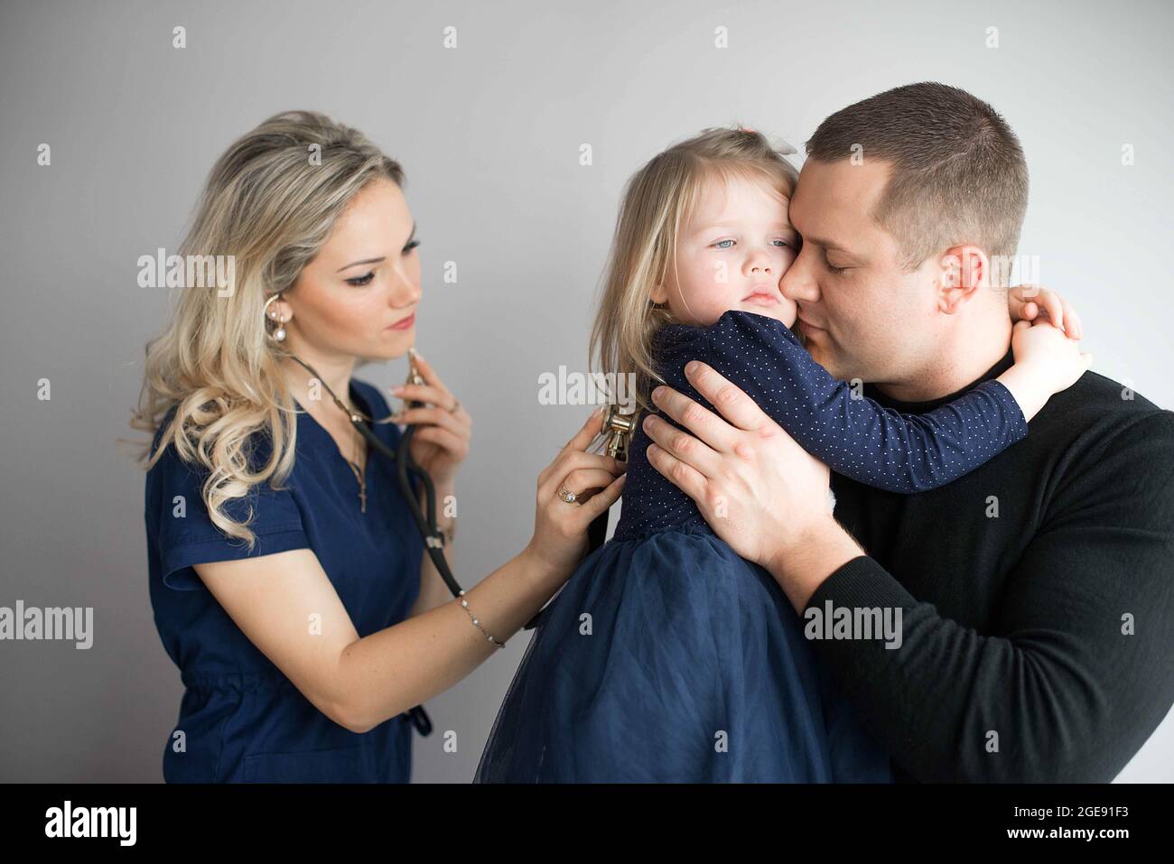 Father with girl being examined by friendly female pediatrician in clinic Stock Photo