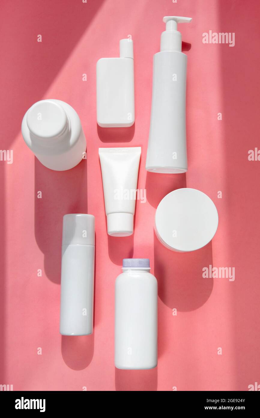 White different types tubes for cosmetics on pink background flatley Stock Photo