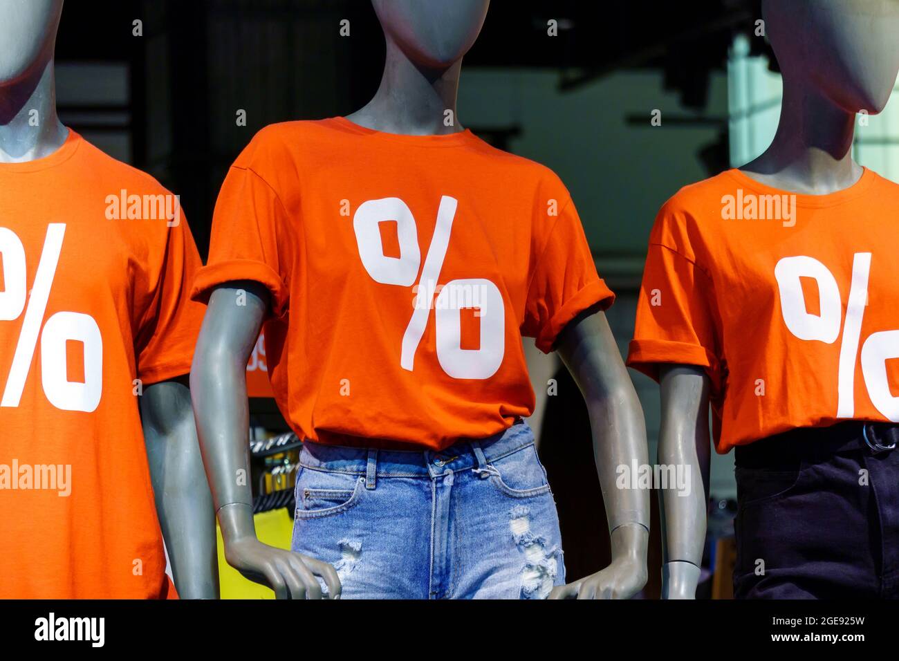 Mannequins in red t-shirts and blue jeans in store window. Sale discount. Black  Friday cheap clothes Stock Photo - Alamy
