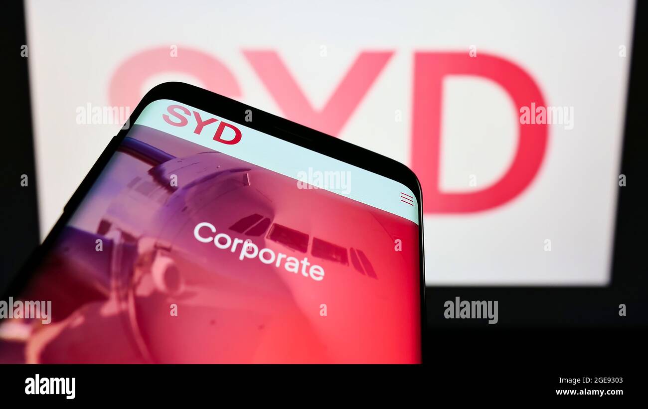 Mobile phone with website of Australian company Sydney Airport Holdings Pty Ltd on screen in front of logo. Focus on top-left of phone display. Stock Photo
