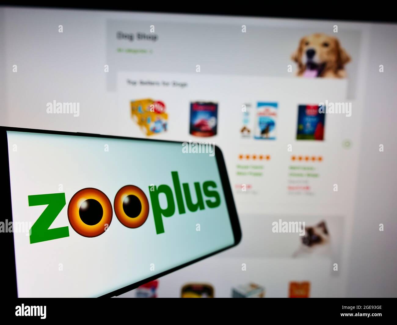 Mobile phone with logo of German pet food retail company Zooplus AG on screen in front of business website. Focus on left of phone display. Stock Photo