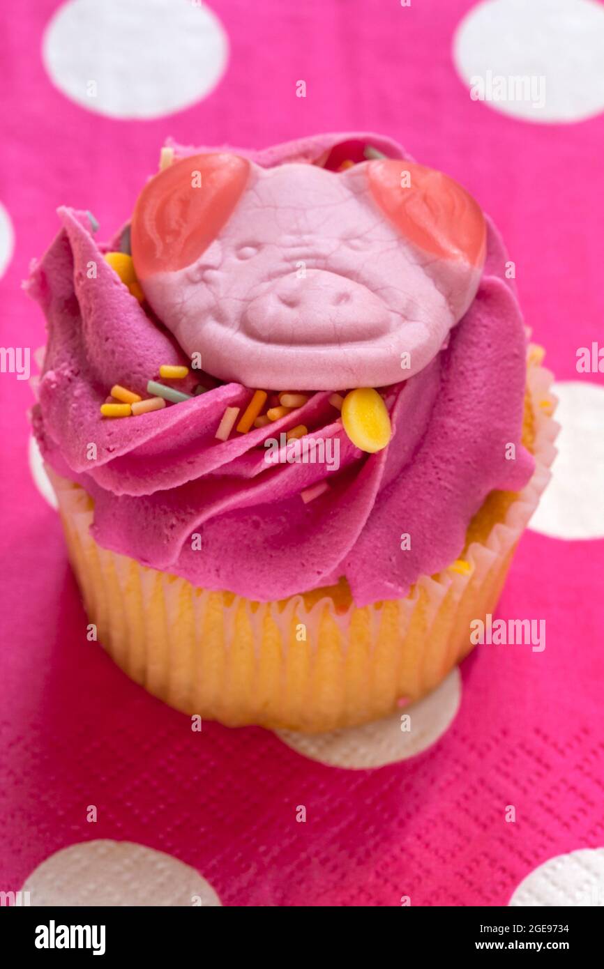 Percy Pig party cupcake cake from M&S set on pink polka dot serviette napkin Stock Photo