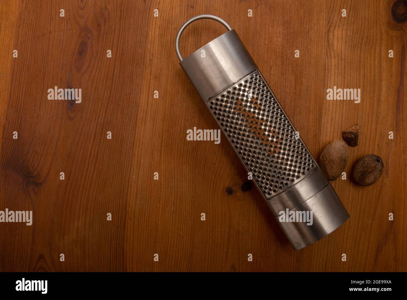 nutmeg grater on a rustic wooden table .cooking concept , spices . Stock Photo