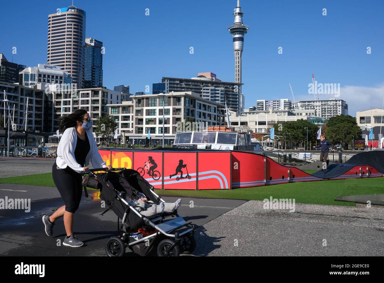 Auckland, New Zealand. 18th Aug, 2021. A woman wearing a face mask walks with a stroller on the street in Auckland, New Zealand, Aug. 18, 2021. New Zealand confirmed three more Delta cases of COVID-19 in the community, bringing the total number of community cases to 10 on Wednesday, including one fully-vaccinated nurse from an Auckland hospital. Credit: Zhao Gang/Xinhua/Alamy Live News Stock Photo