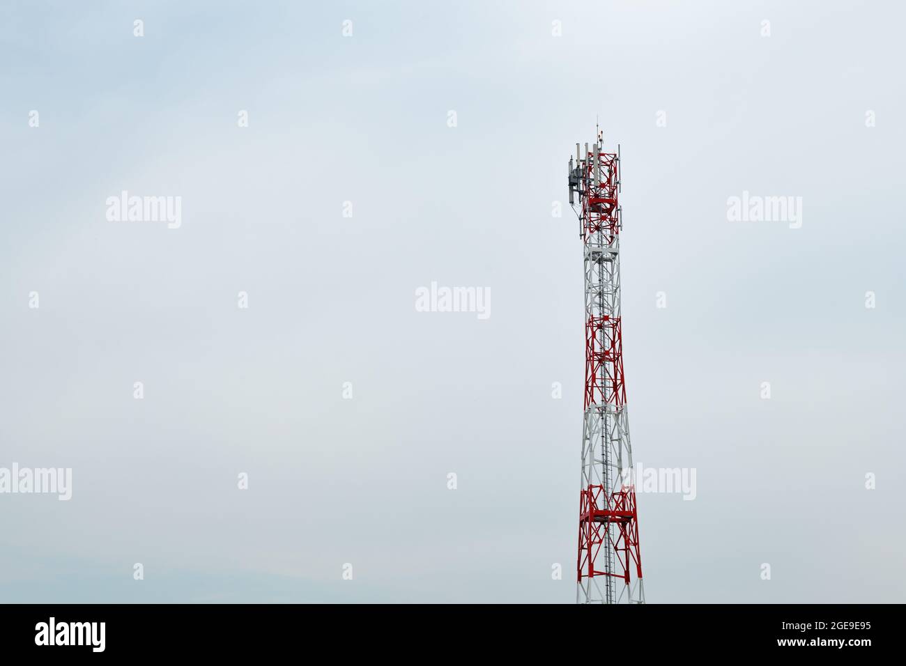 Telecommunication tower with antennas and signal repeaters against overcast sky as copy space Stock Photo