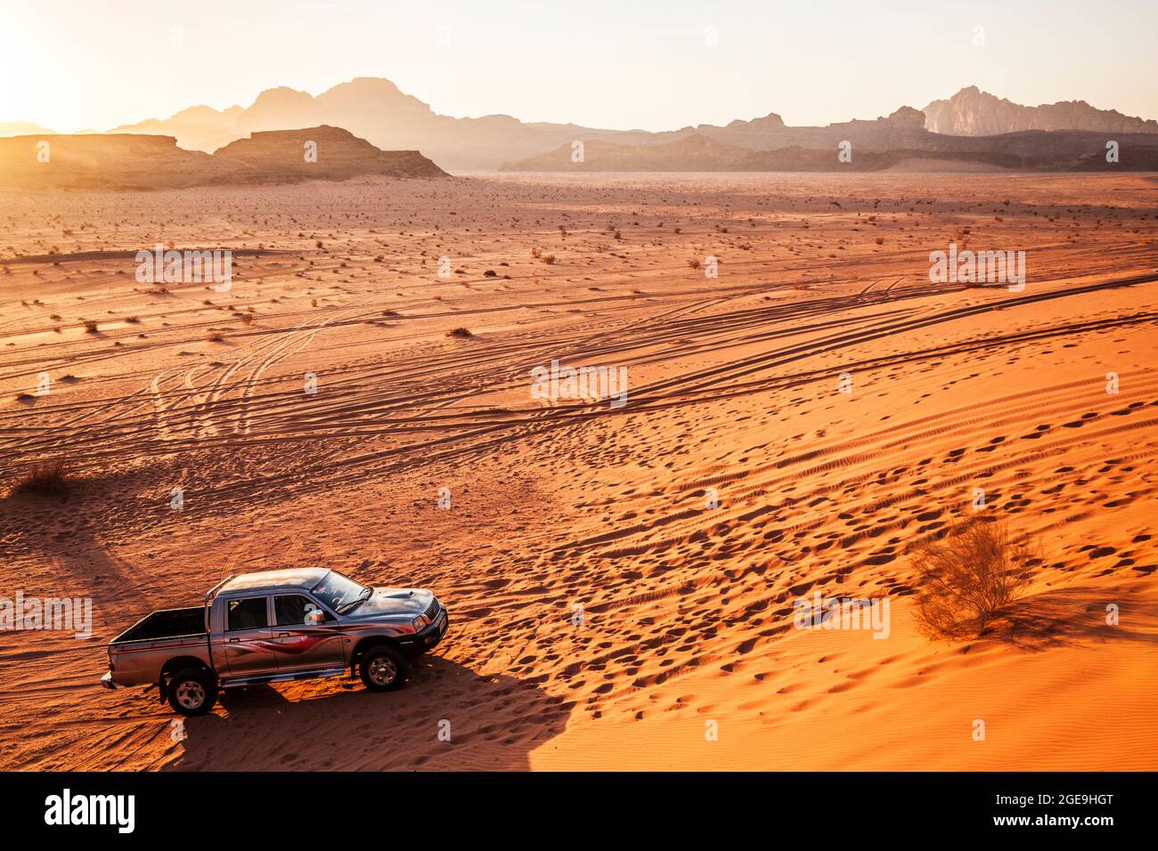 A Mitsubishi tourist jeep at sunset in the Jordanian desert at Wadi Rum or Valley of the Moon. Stock Photo