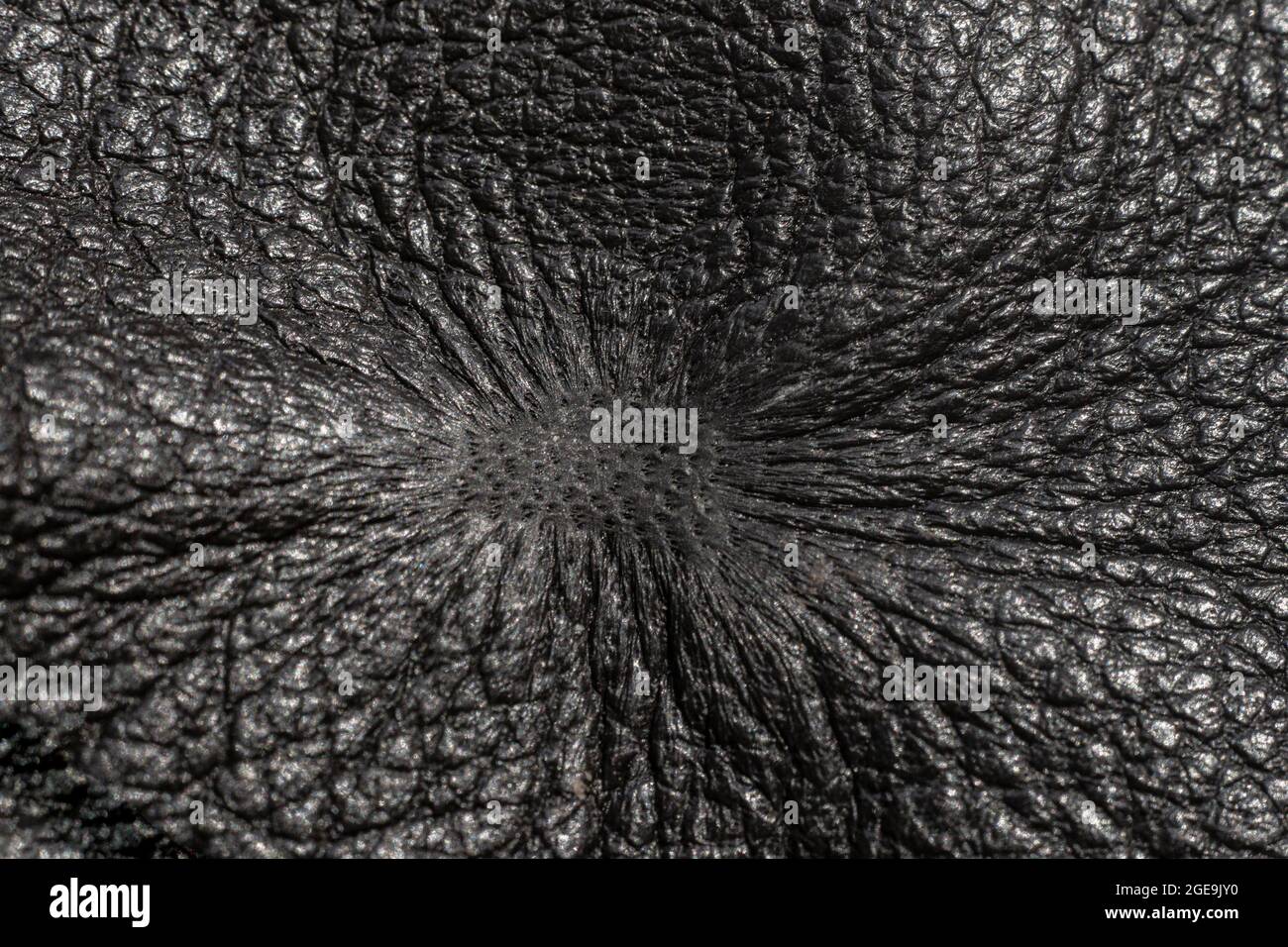 cigarette burn on a black, fake leather sofa, arm chair, furniture