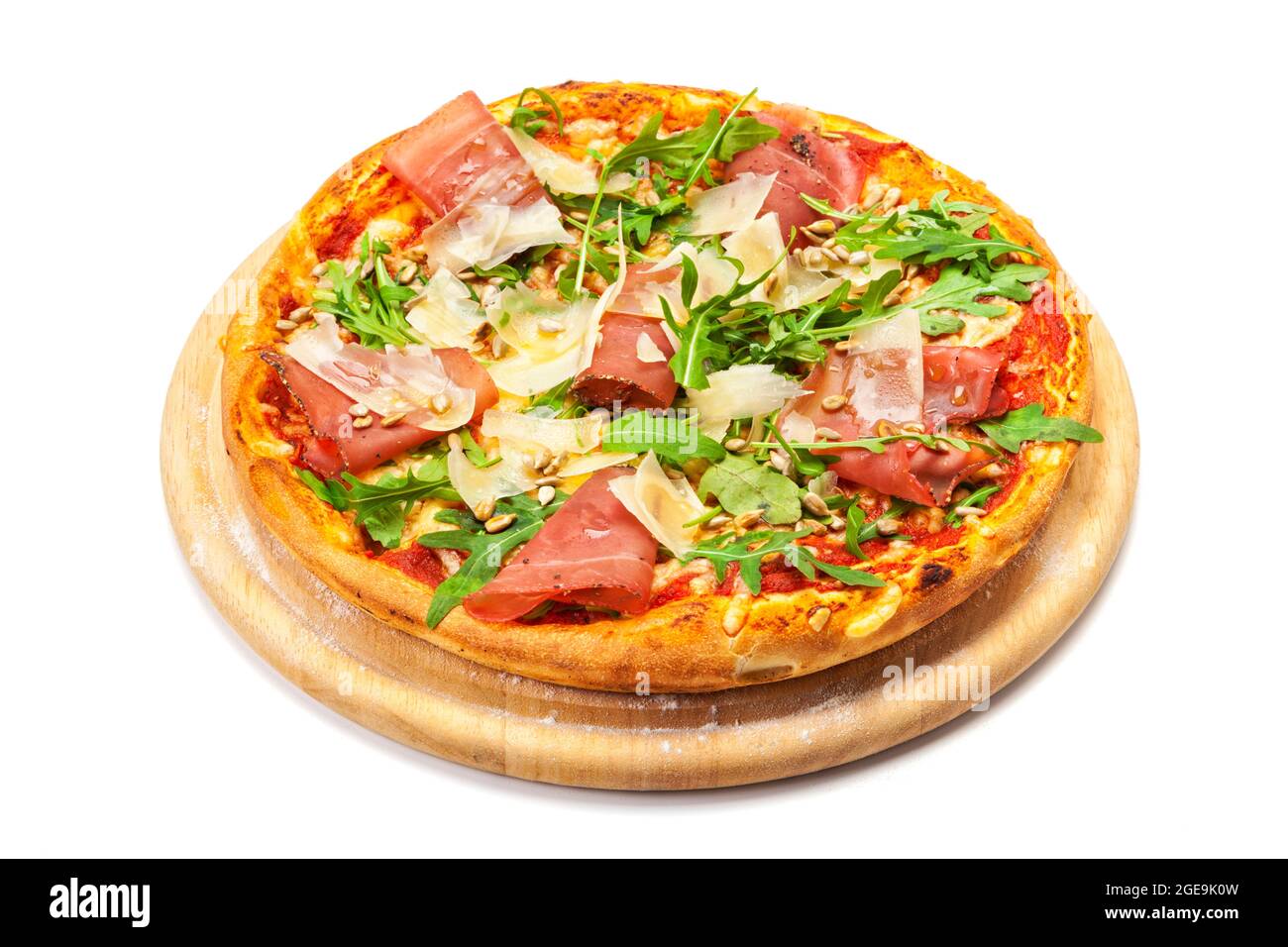 Pizza with dry cured ham, parmesan cheese, rocket leaves and ipne nuts on wooden platter, isolated on white background with clipping path Stock Photo