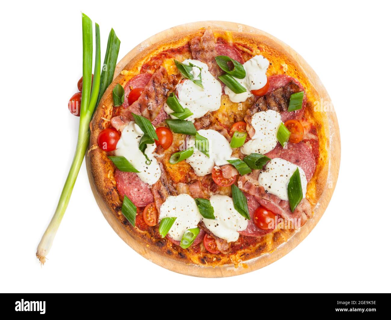 Pizza with salami, bacon, sour cream, tomatoes and spring onions on wooden platter  isolated on white background, high angle view Stock Photo