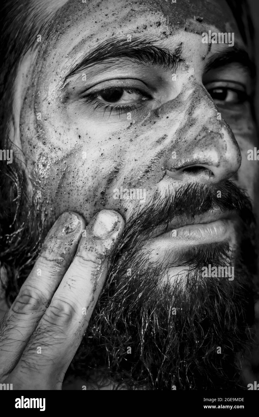 Tight black and white portrait of a bearded middle eastern man putting