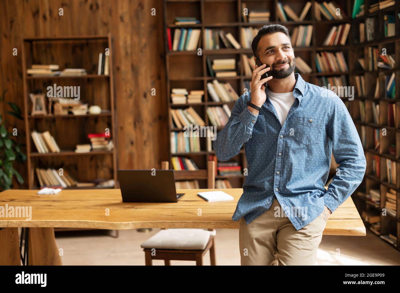 Happy inspired Indian male small business owner talks on the