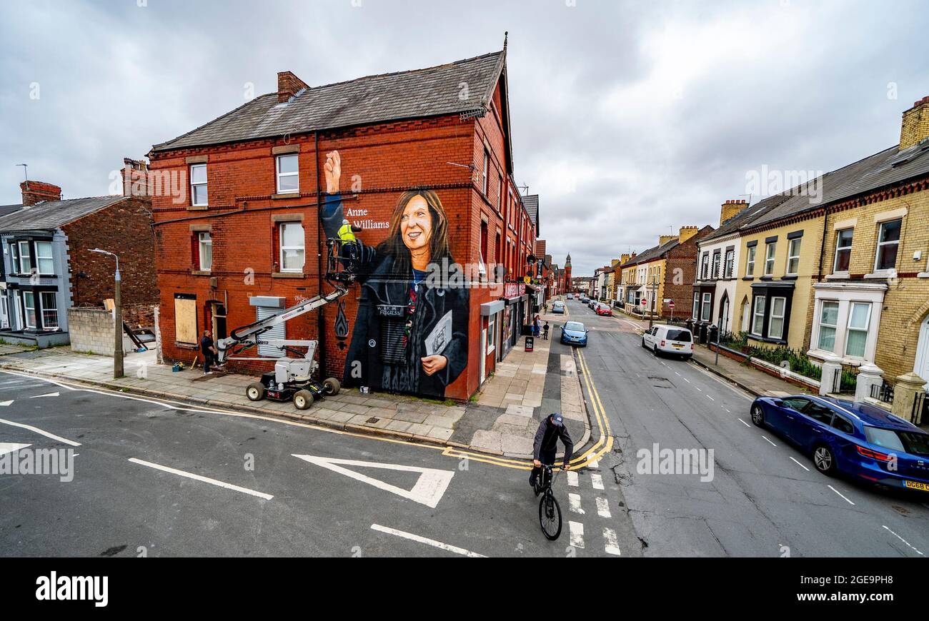 Artist Paul Curtis paints a mural of Anne Williams, the mother of