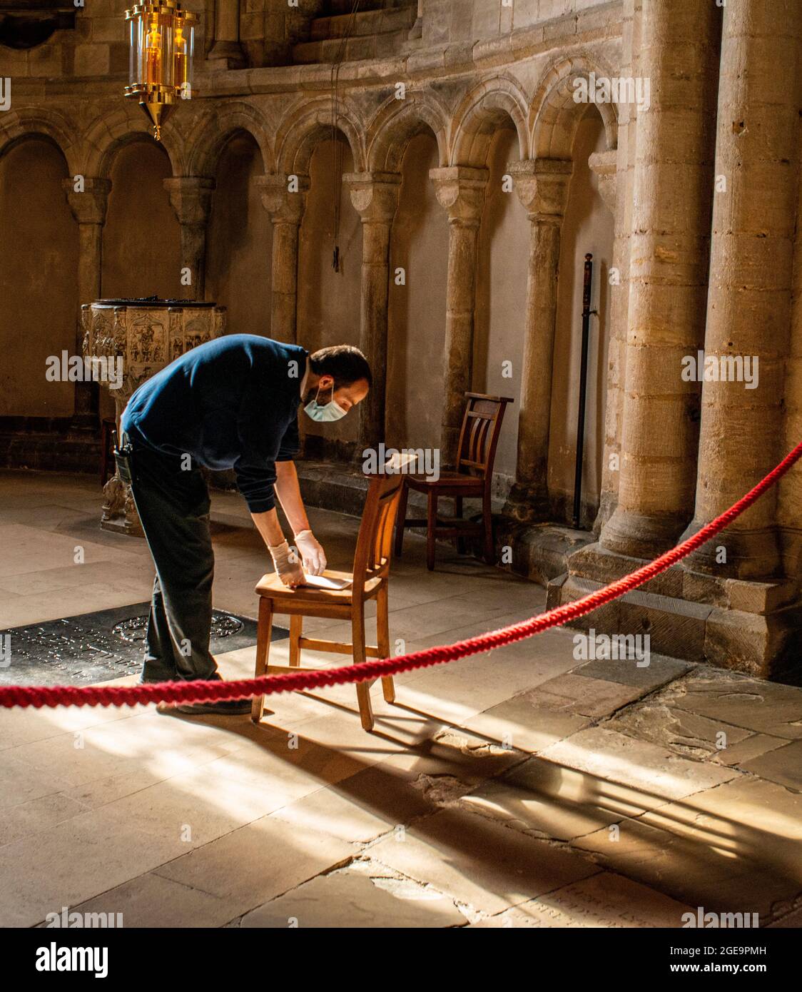 Man wearing face mask working in Norwich Cathedral in Norfolk in England. Stock Photo