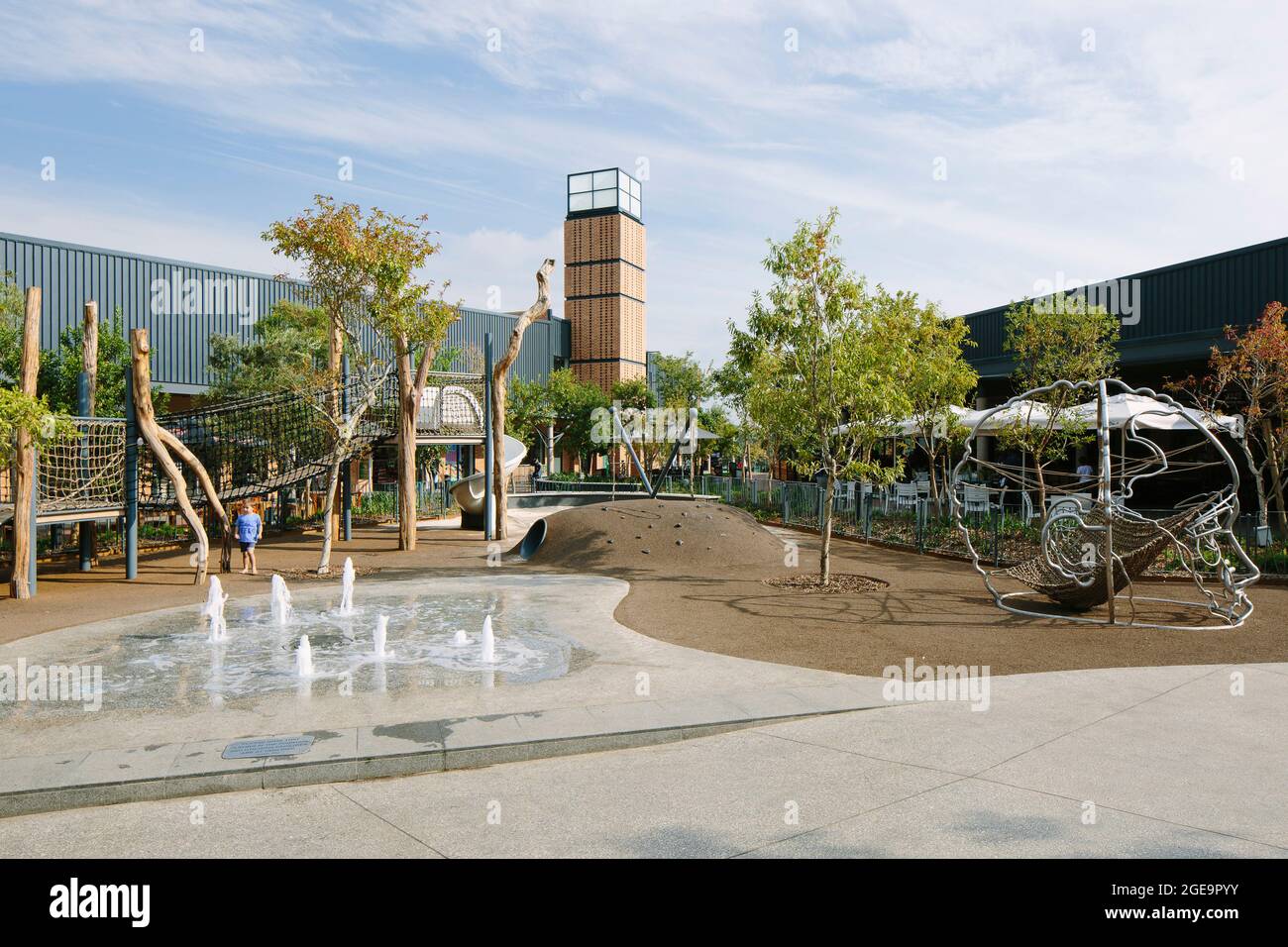 Main piazza exterior with water feature, landscaping and jungle gyms