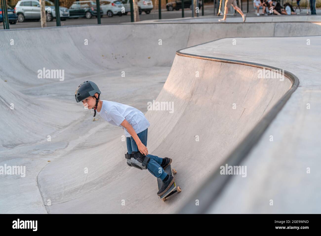 Teenage boy jumping with skateboard and showing stunt on ramp in skate