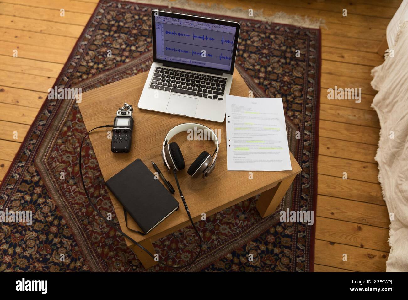 From above of audio recorder and headphones placed on wooden table with laptop and notebook for recording podcast at home Stock Photo